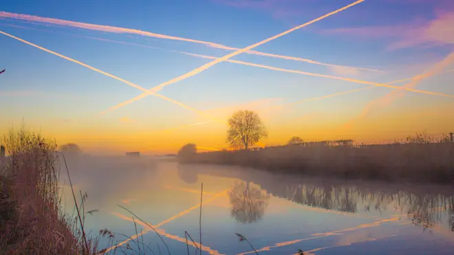 Zonsopkomt in Buurmalsen, het zijn vliegtuigstrepen die de lucht kleuren - Ab Donker