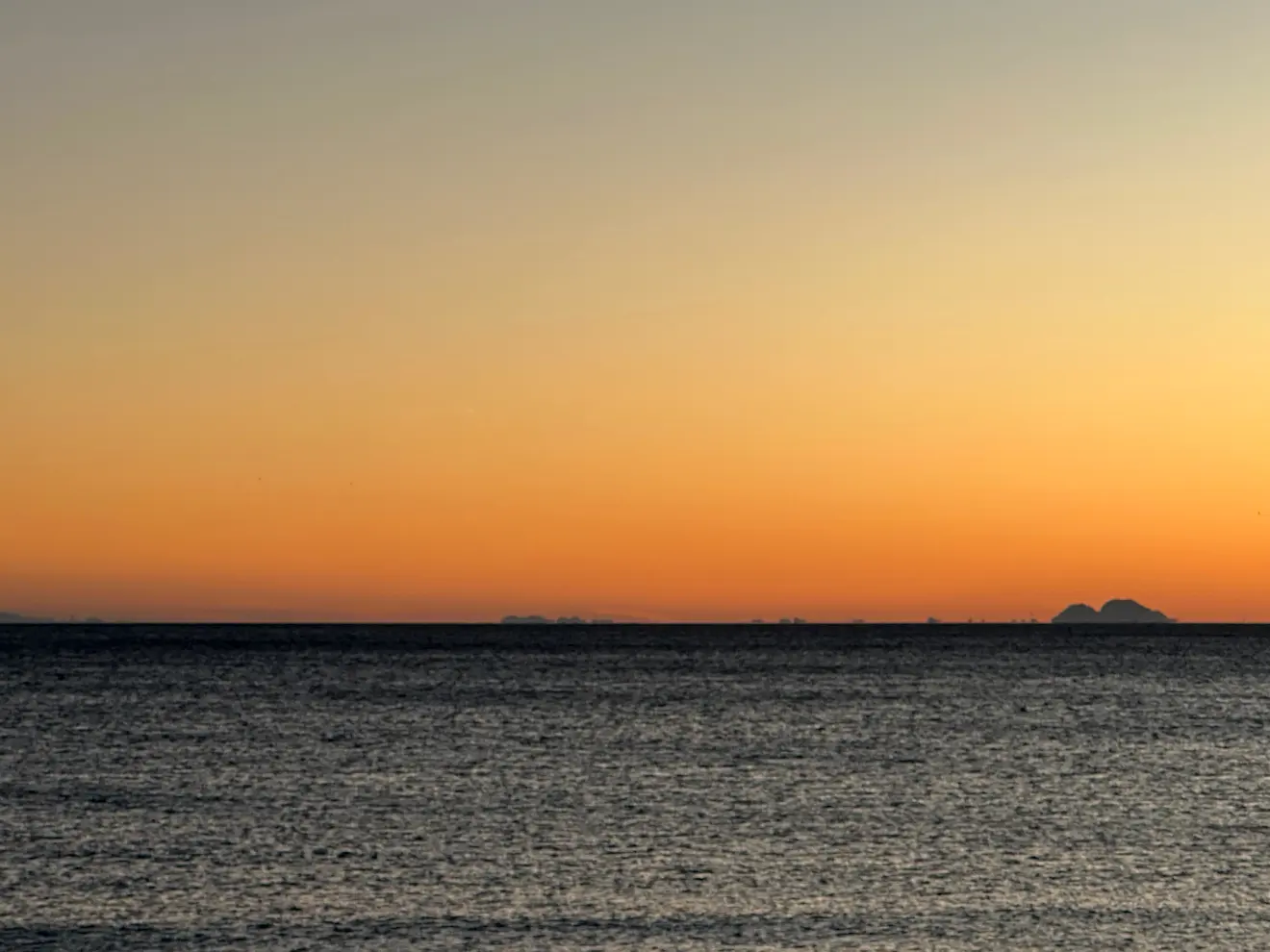 Een rij schepen op weg naar de Straat van Gibraltar. Door een luchtspiegeling lijken de schepen wat boven de horizon te zijn getild - Tycho van den Born