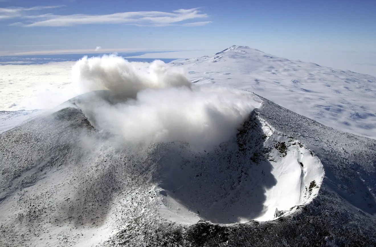 De twee kraters van Mount Erebus. De krater met de wolk erboven is die met het lavameer erin. Op de achtergrond de slapende vulkaan Mount Waesche - Josh Landis