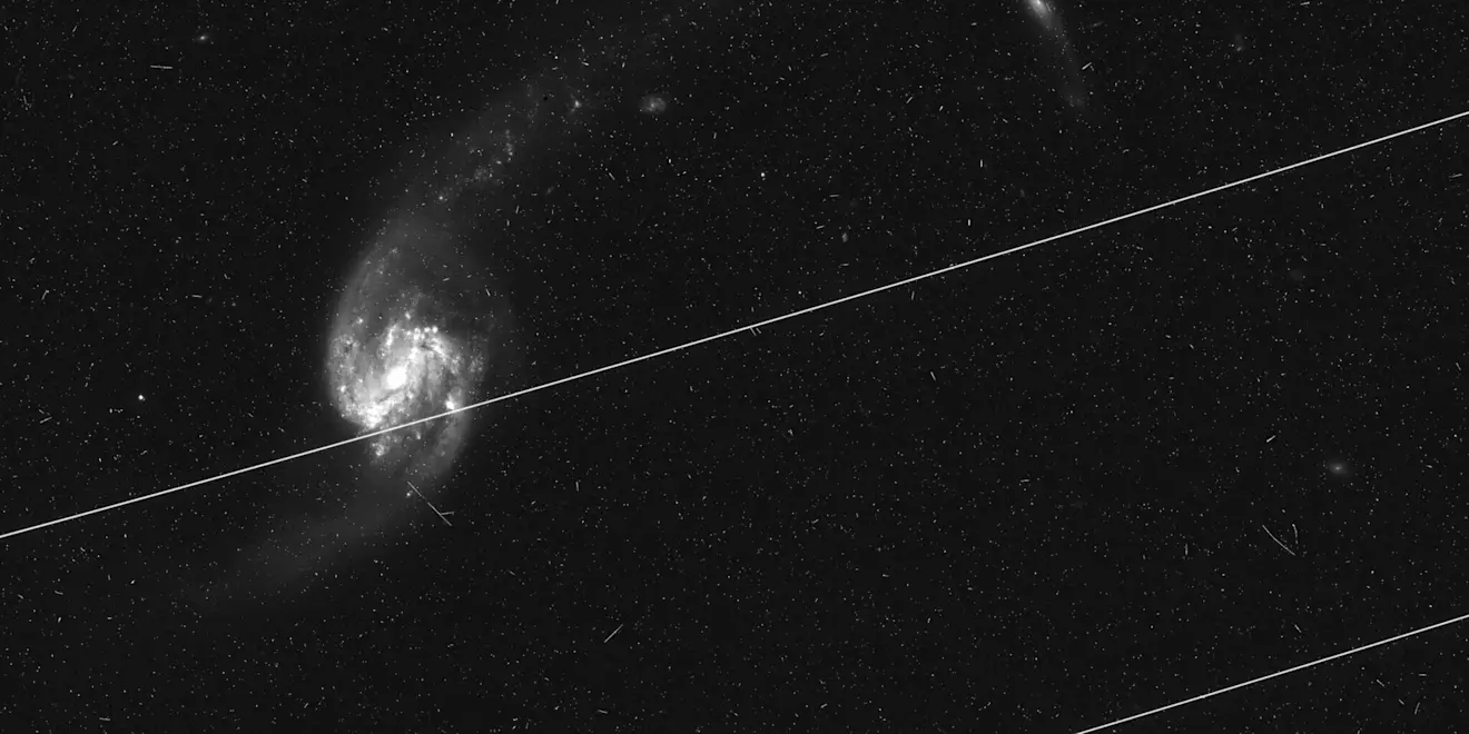 Satellieten trekken lichtsporen door een astronomische opname van de Hubble-ruimtetelescoop. Foto: NASA/ESA/Kruk et al./Nature 2023, via IAU, CC BY 4.0.