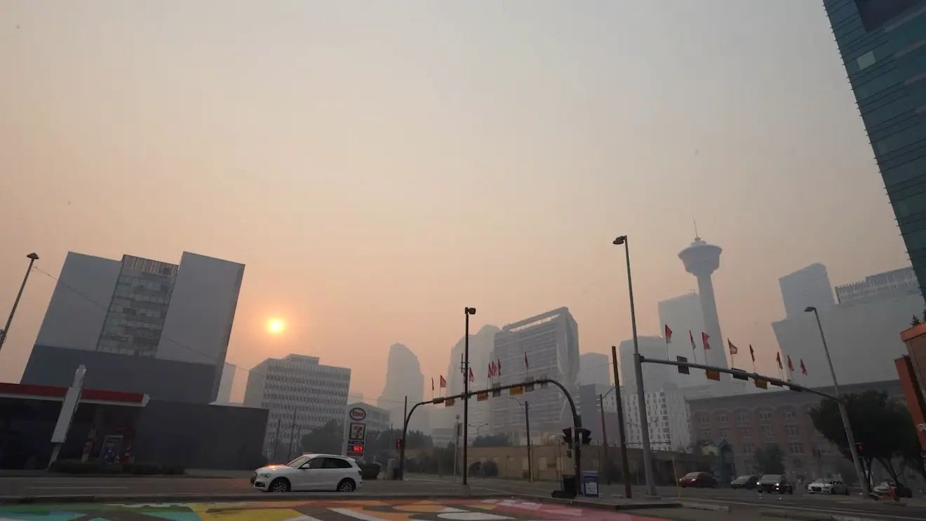 De zon schijnt versluierd door rook van bosbranden in Calgary op 21 juli 2024 - Katherine KY Cheng