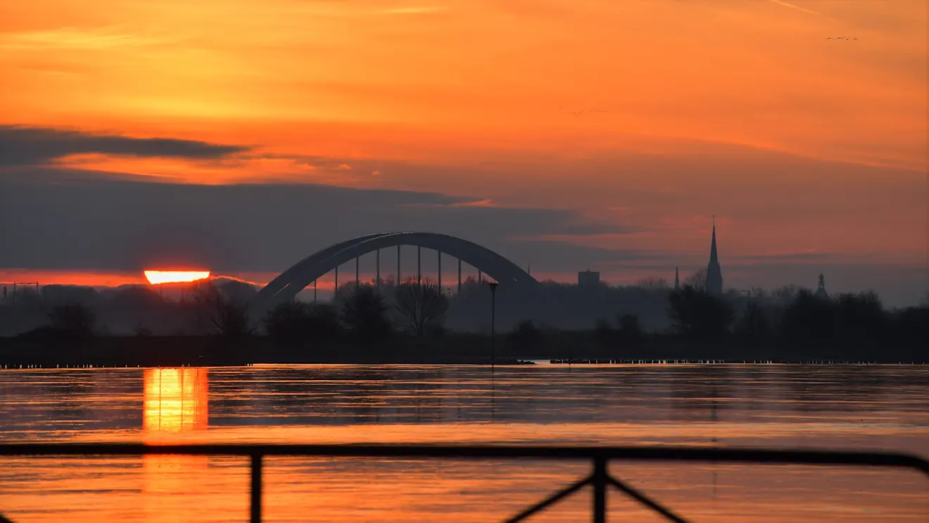De lentezon kleurt de rivier oranje - Cynthia van Leusden