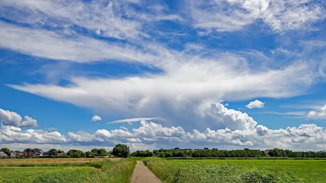 Prachtig uitgesponnen buienwolken staken fel wit af tegen een staalblauwe lucht - Simone Wiersma