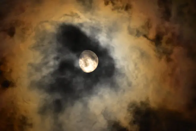 De heldere maan schijnt donderdagavond door de wolken - Cynthia van Leusden