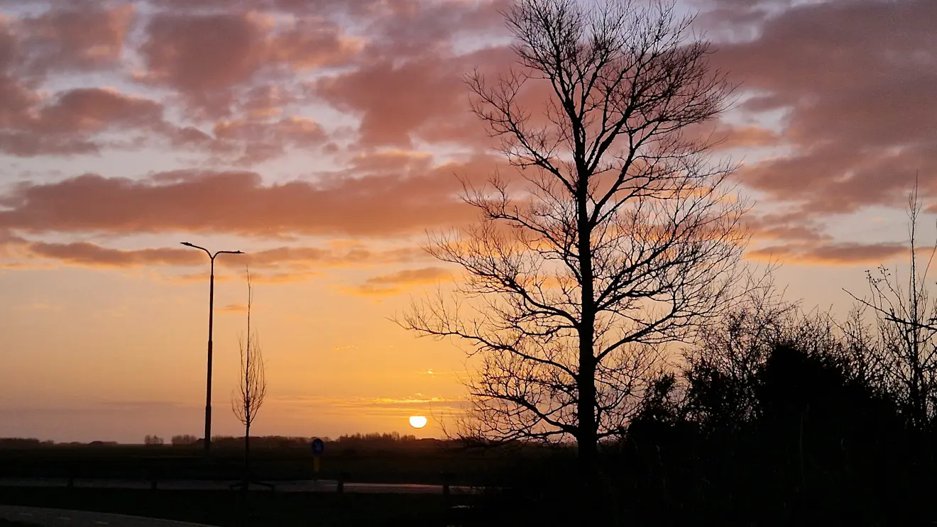 De zon komt in pasteltinten op, boven Texel - Frans Alderse Baas
