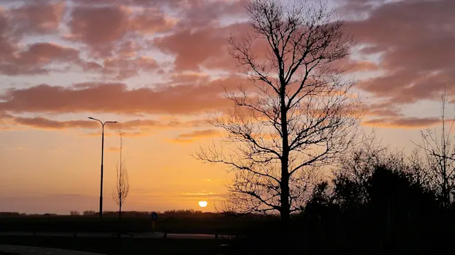 De zon komt in pasteltinten op, boven Texel - Frans Alderse Baas