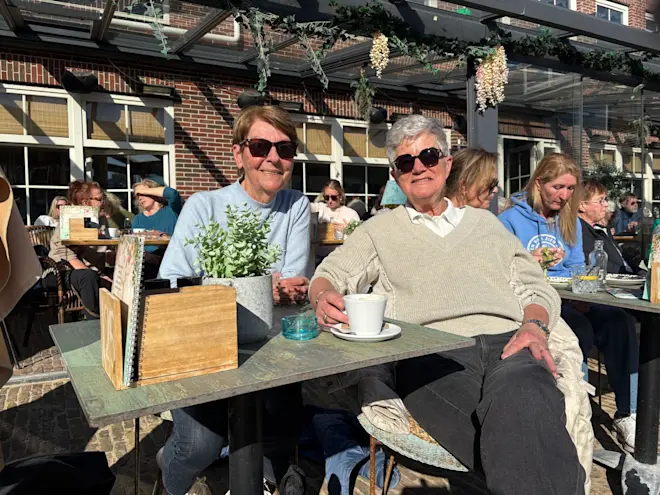 Marion en Anna genieten in Egmond aan Zee van de warme winterzon - Pieter Bliek