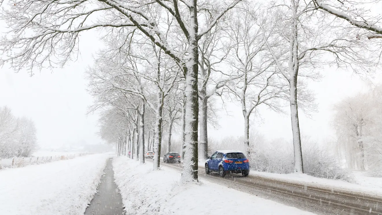 Het verkeer ploetert door de sneeuw bij Beers - Henk Straatman