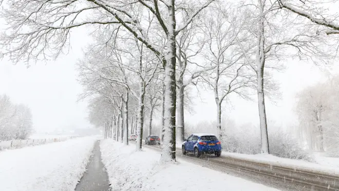 Het verkeer ploetert door de sneeuw bij Beers - Henk Straatman