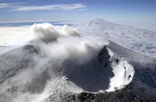 De twee kraters van Mount Erebus. De krater met de wolk erboven is die met het lavameer erin. Op de achtergrond de slapende vulkaan Mount Waesche - Josh Landis