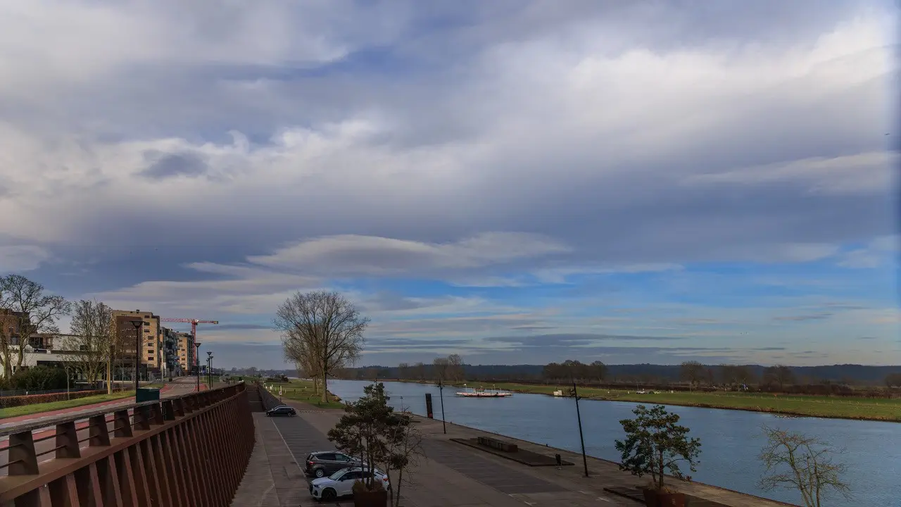 Wolken en zon boven de Maas in Cuijk - Henk Straatman