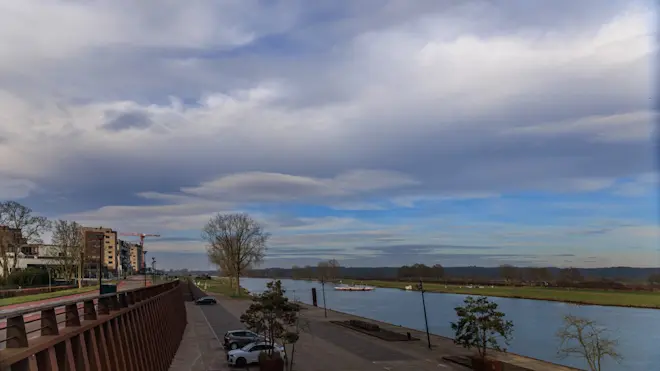 Wolken en zon boven de Maas in Cuijk - Henk Straatman