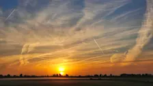 Zonsopkomst bij Dronten. Veel vliegtuigstrepen in de lucht - Jannine Sanders