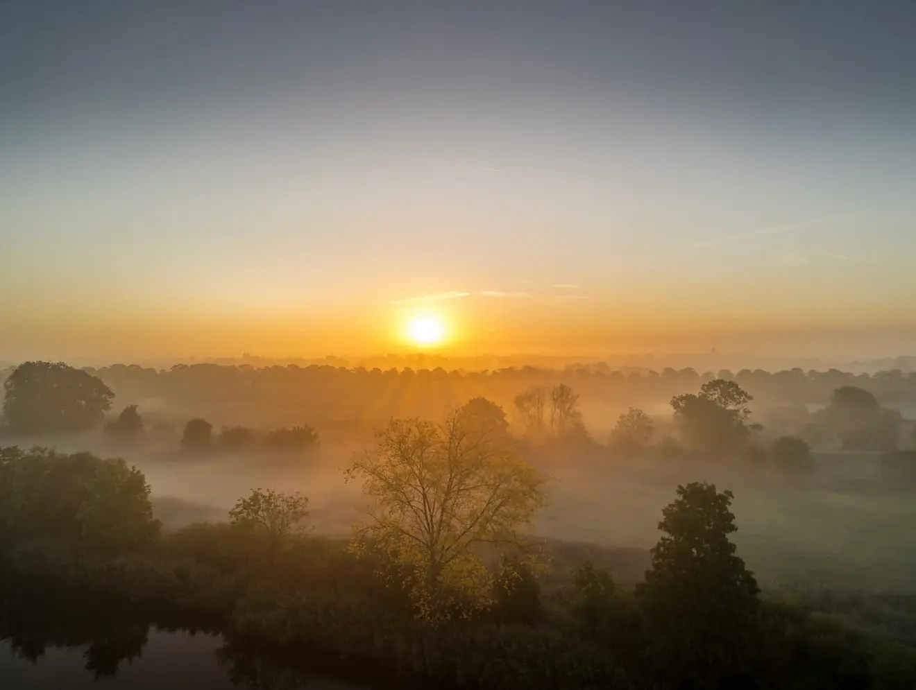De zon komt in Leerdam op boven laaghangende mist - John Oomen