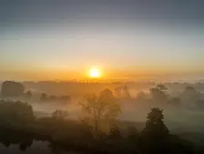 De zon komt in Leerdam op boven laaghangende mist - John Oomen