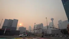 De zon schijnt versluierd door rook van bosbranden in Calgary op 21 juli 2024 - Katherine KY Cheng