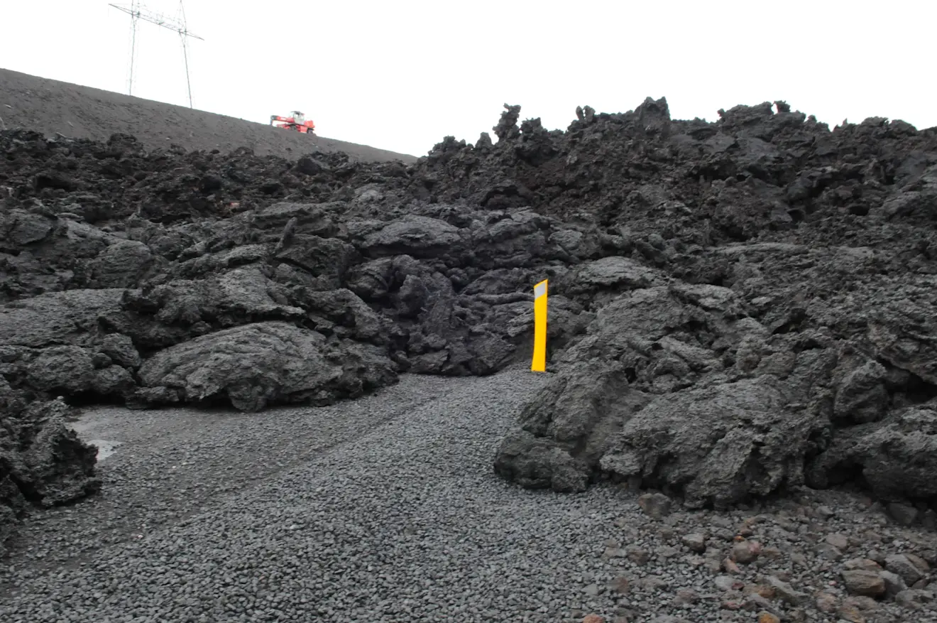 Lava op de weg, met de dijk erachter - Pieter Bliek