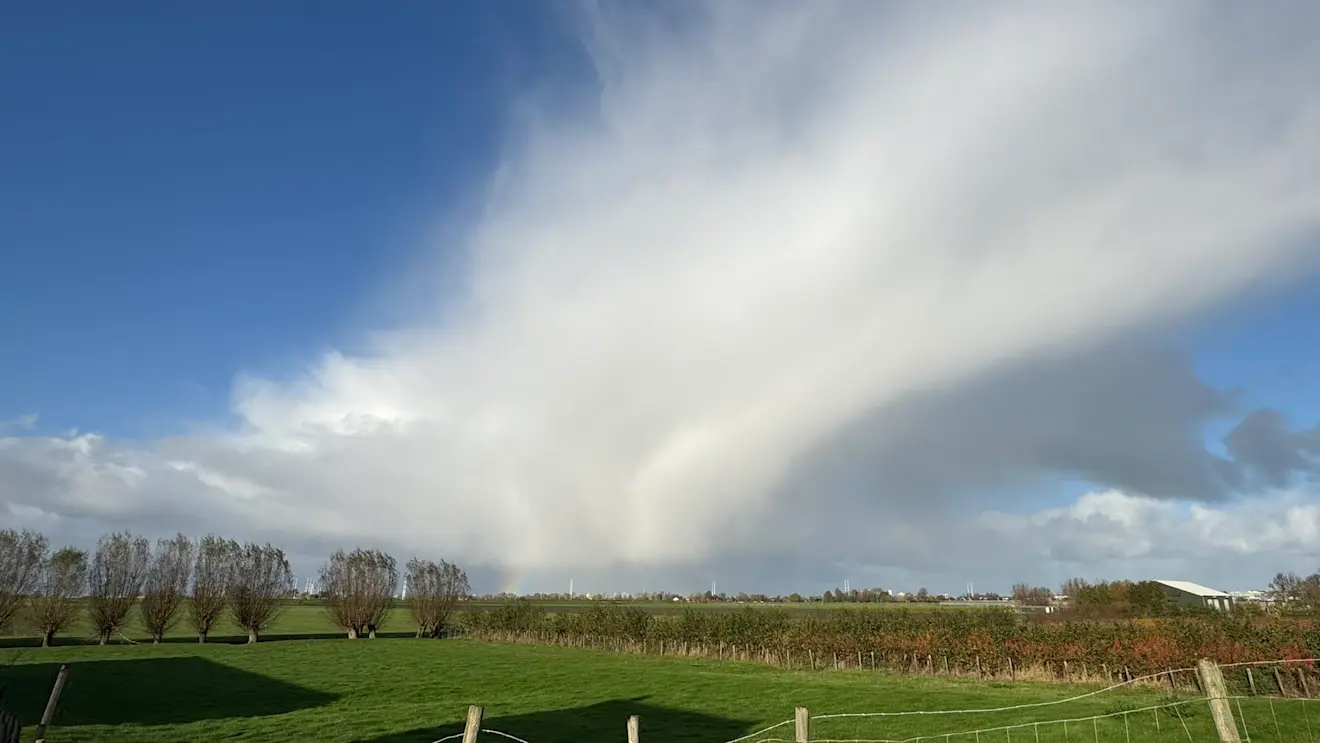 Een fraaie bui met daaronder een regenboog - Jolanda Bakker