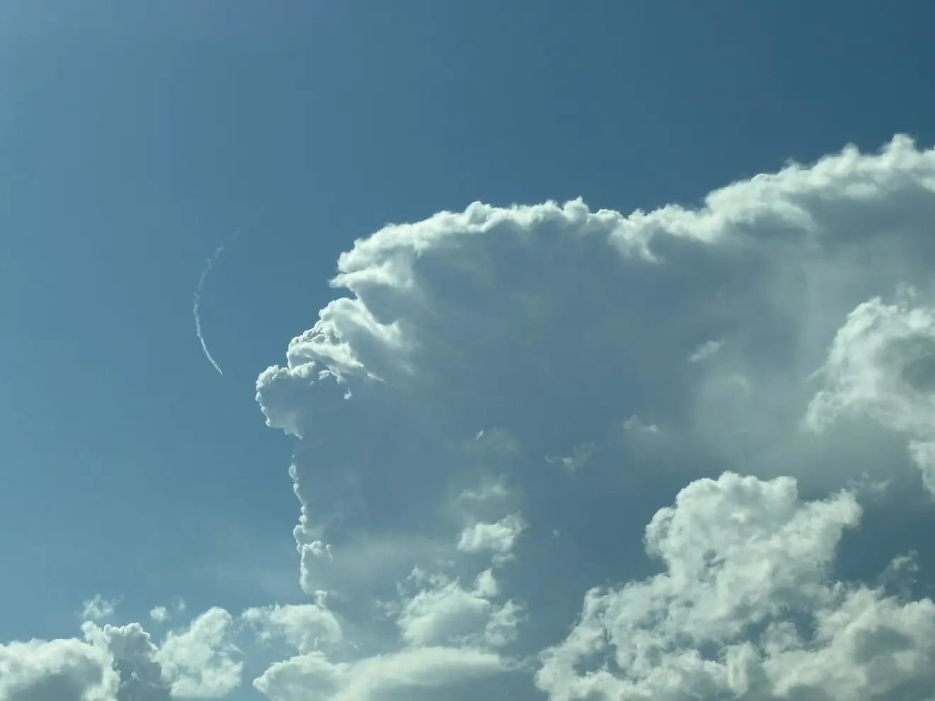 Een buienwolk schiet de hoogte in, een vliegtuig wijkt uit - Tjitske Wiebenga