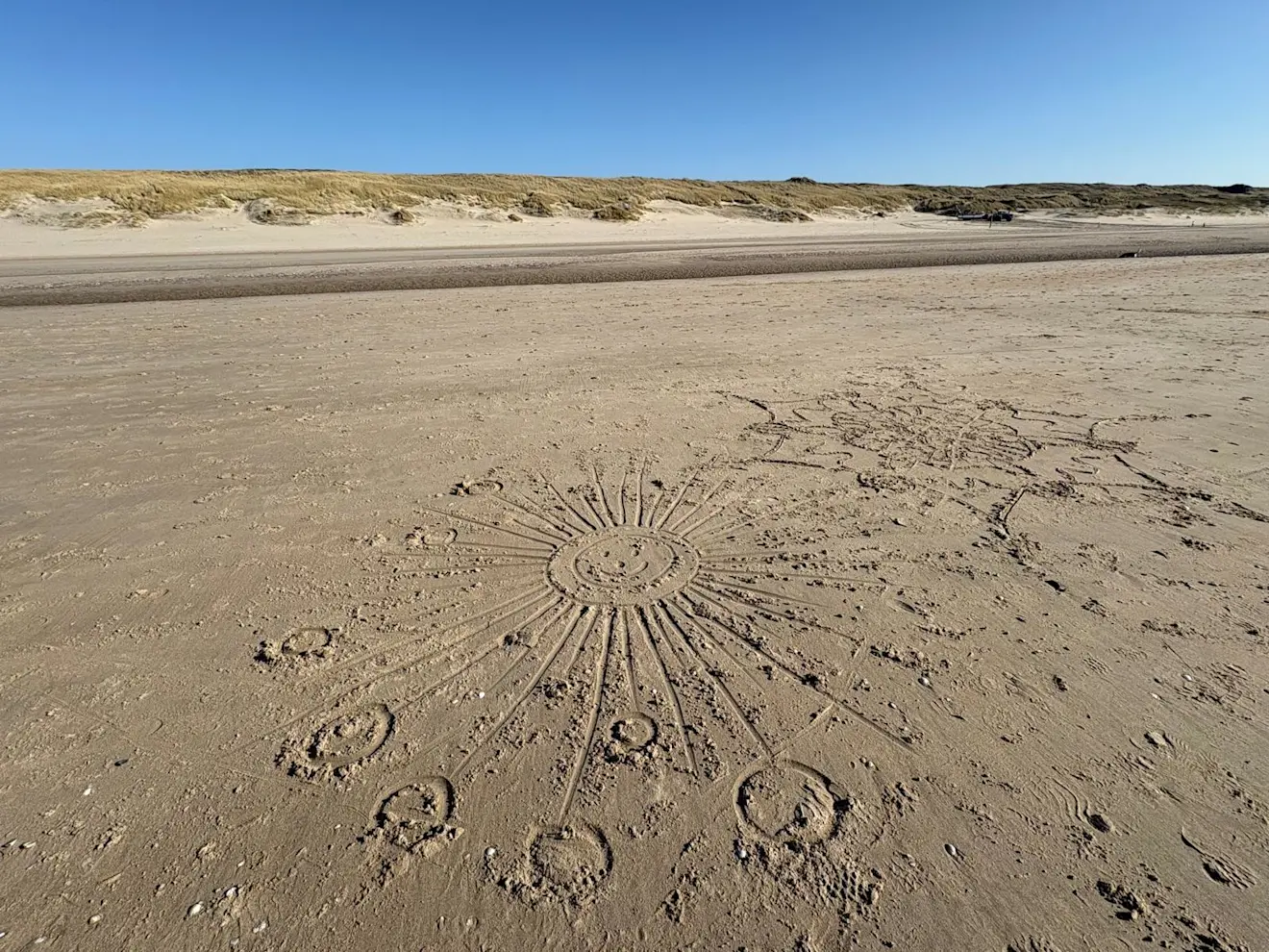 De zon stuurt straling naar het strand van Egmond aan Zee. Het zand zet de invallende, kortgolvige zonnestraling om in langgolvige warmtestraling - Pieter Bliek