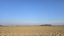 Kale velden in Noordoost-Groningen, met daarboven een blauwe lucht - Jannes Wiersema